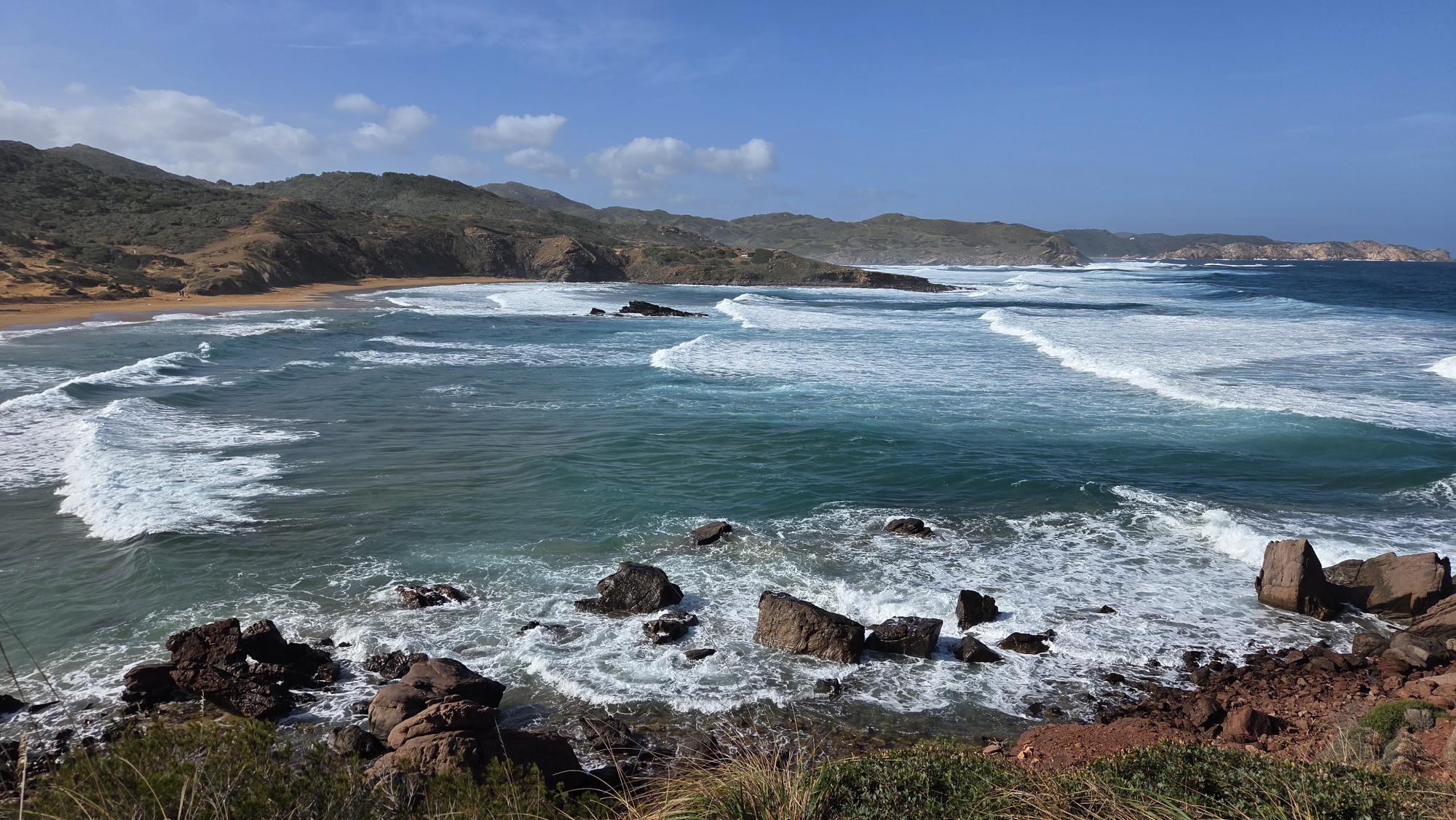 North coast Menorca rocky beach red sand